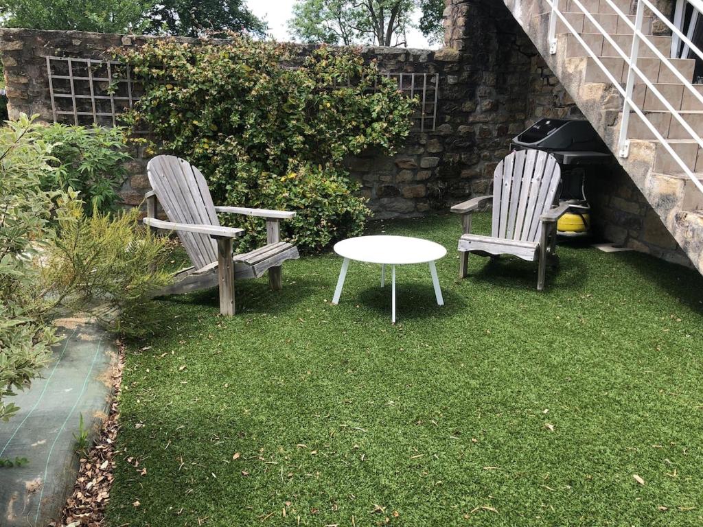 zwei Stühle und ein Tisch in einem Garten in der Unterkunft Gîte Penn trech 2 chambres in Arradon