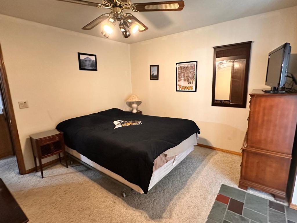 een slaapkamer met een bed en een plafondventilator bij Whispering Pines Auburn in Auburn