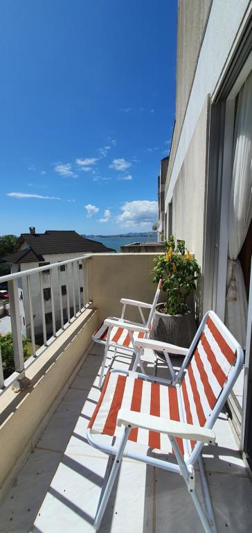 two lawn chairs sitting on a balcony with a window at Quarto in São José
