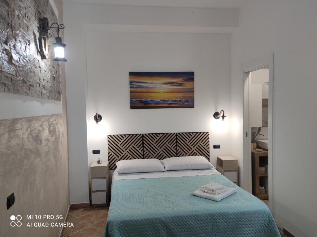 ein Schlafzimmer mit einem Bett mit einer blauen Decke in der Unterkunft B&B Borgo Storico dei Marinai in Cirò Marina