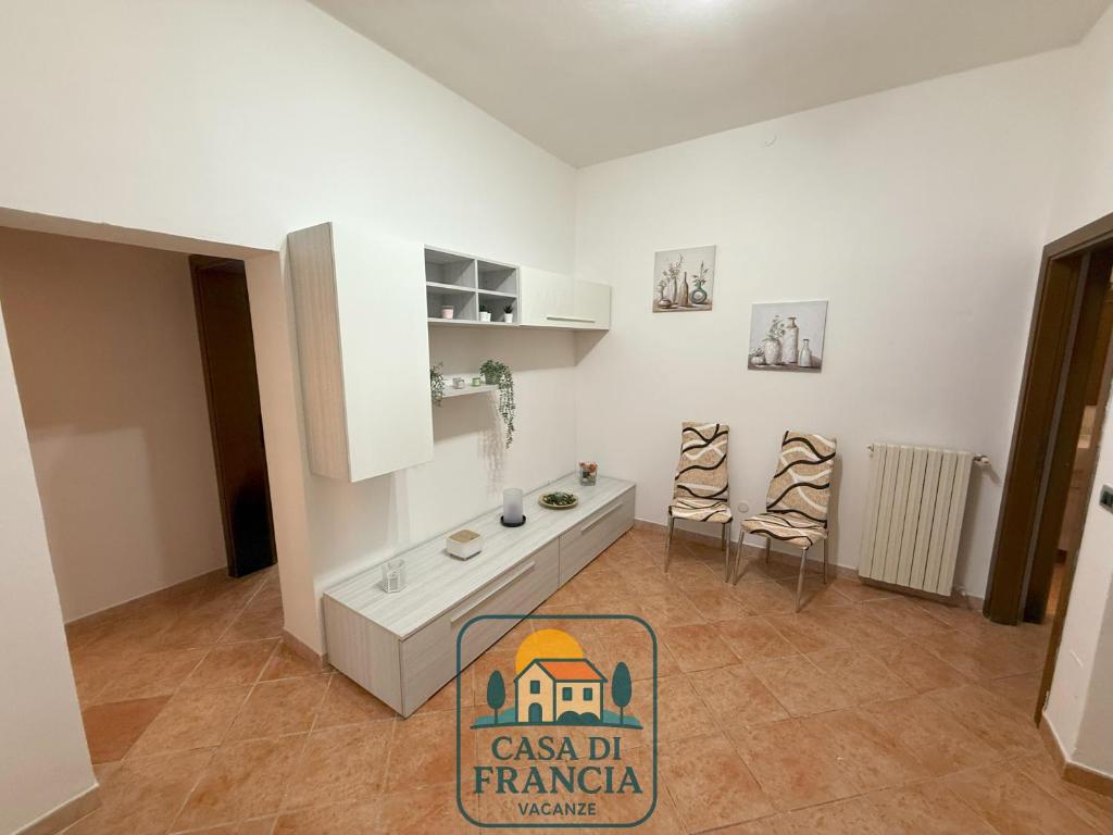 a kitchen with a counter and two chairs in a room at Casa Di Francia in Pontedera