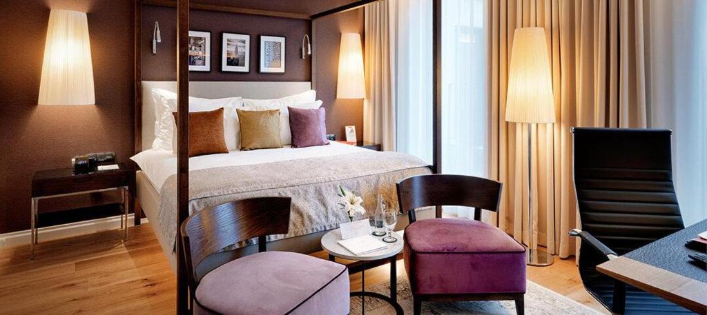 ジェシュフにあるB&amp;B HOTEL RZESZÓW CENTRUMのベッドとテーブルと椅子のあるホテルの部屋