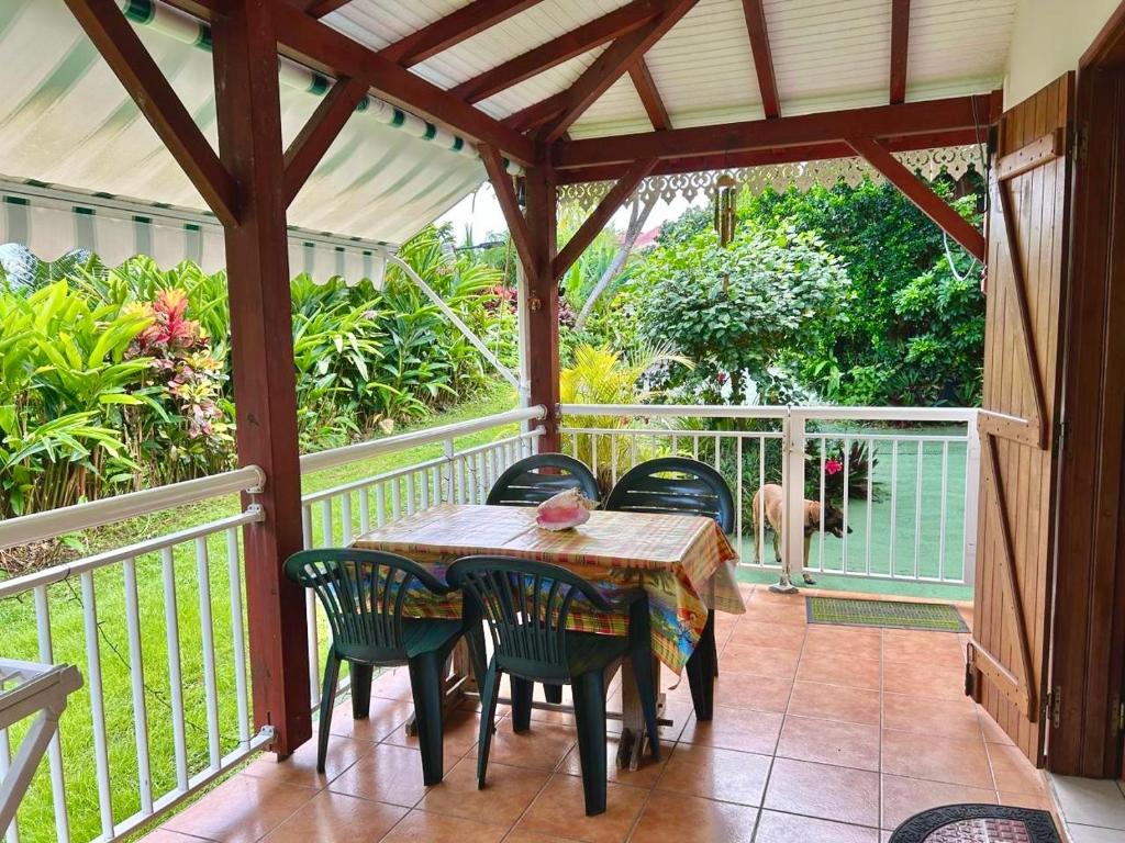 a porch with a table and chairs on it at Le Jardin Créole Gîte chaleureux à Trois-Rivières in Trois-Rivières