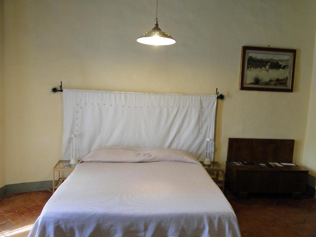1 dormitorio con 1 cama con manta blanca en La Guardia B&B, en Stia