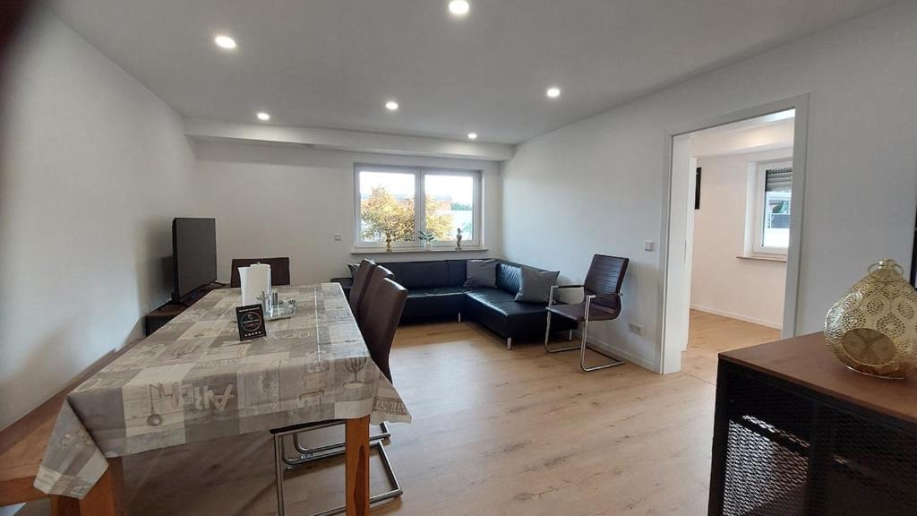 a living room with a table and a couch at Fewo Gerda im schönen Odw in Mörlenbach