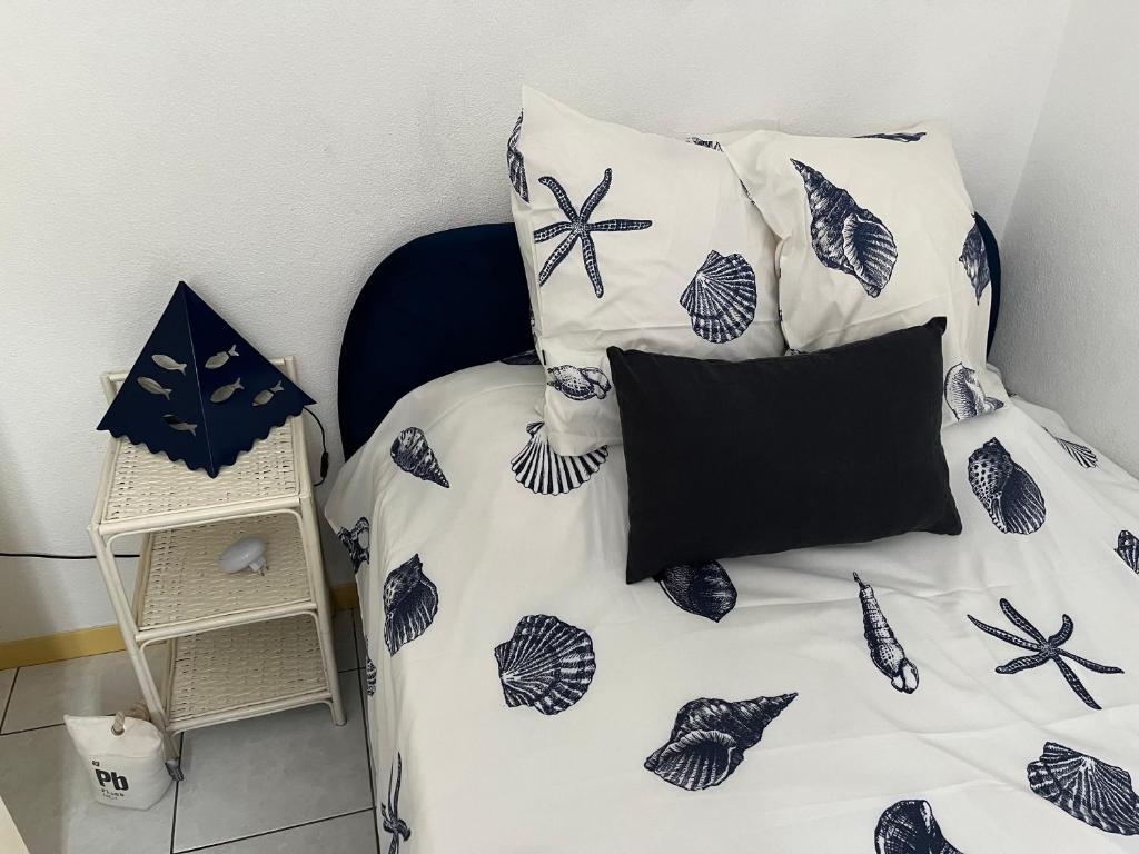 een slaapkamer met een bed met blauwe en witte kussens bij Pavillon de vacances chic et moderne in Plage dʼArgelès