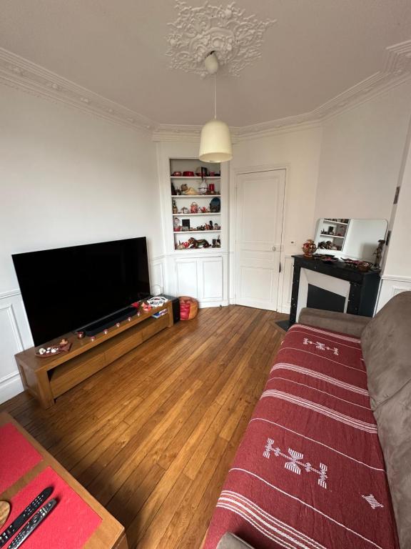 a living room with a pool table and a flat screen tv at Suresnes - culture et détente in Suresnes