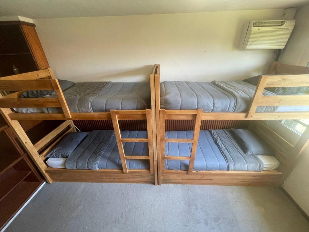 two bunk beds are in a small room at Bergamota Hostel in Curitiba