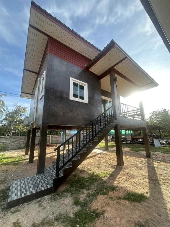 a house with a staircase leading up to it at Wimanthara houses in Thongsala
