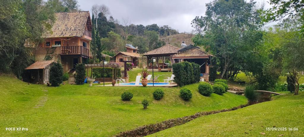 una casa en una colina con un patio verde en Chale Nossa Senhora Aparecida, en Cunha