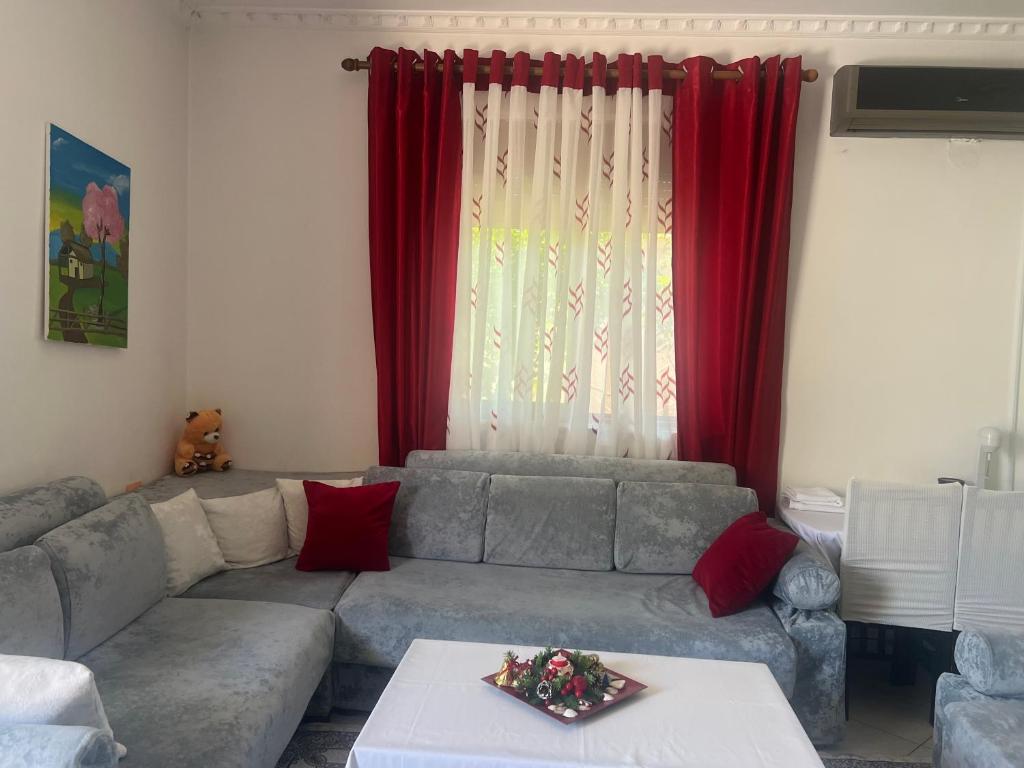 a living room with a couch and red curtains at Ersi Apartment in Durrës