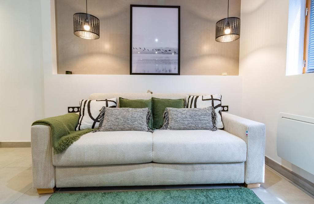 a couch in a living room with two lights at Bethesda - 10 minutes à pied gare - Stationnement gratuit rue in Troyes