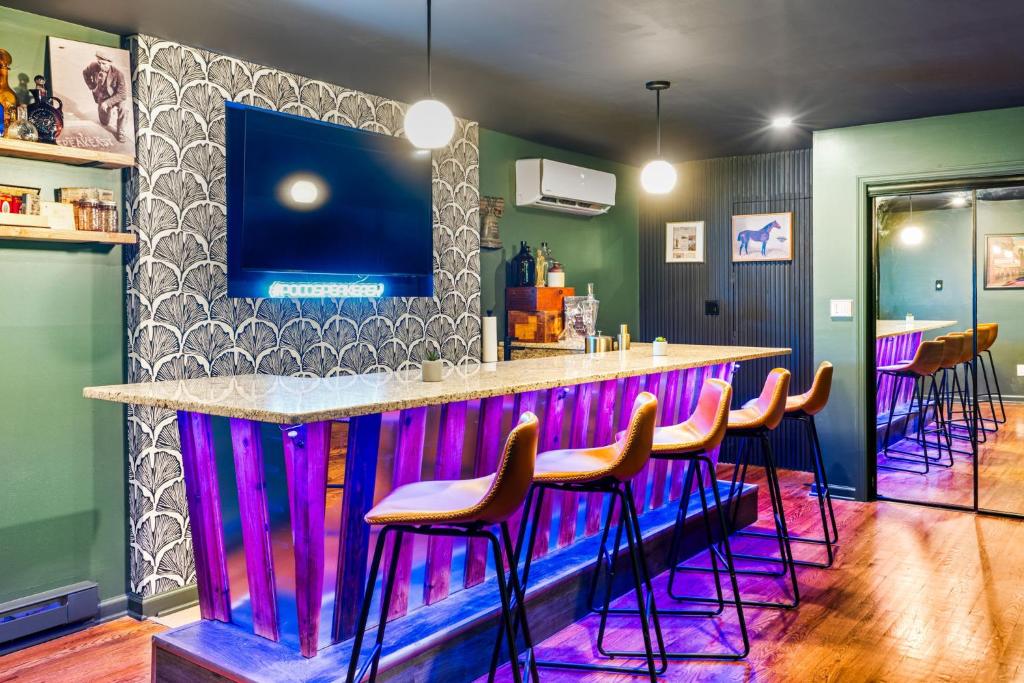 eine Bar mit rosa und lila Barhockern in der Unterkunft Pocono Speak Easy Hot Tub Golf Simulator 1920 Bar in Mount Zion