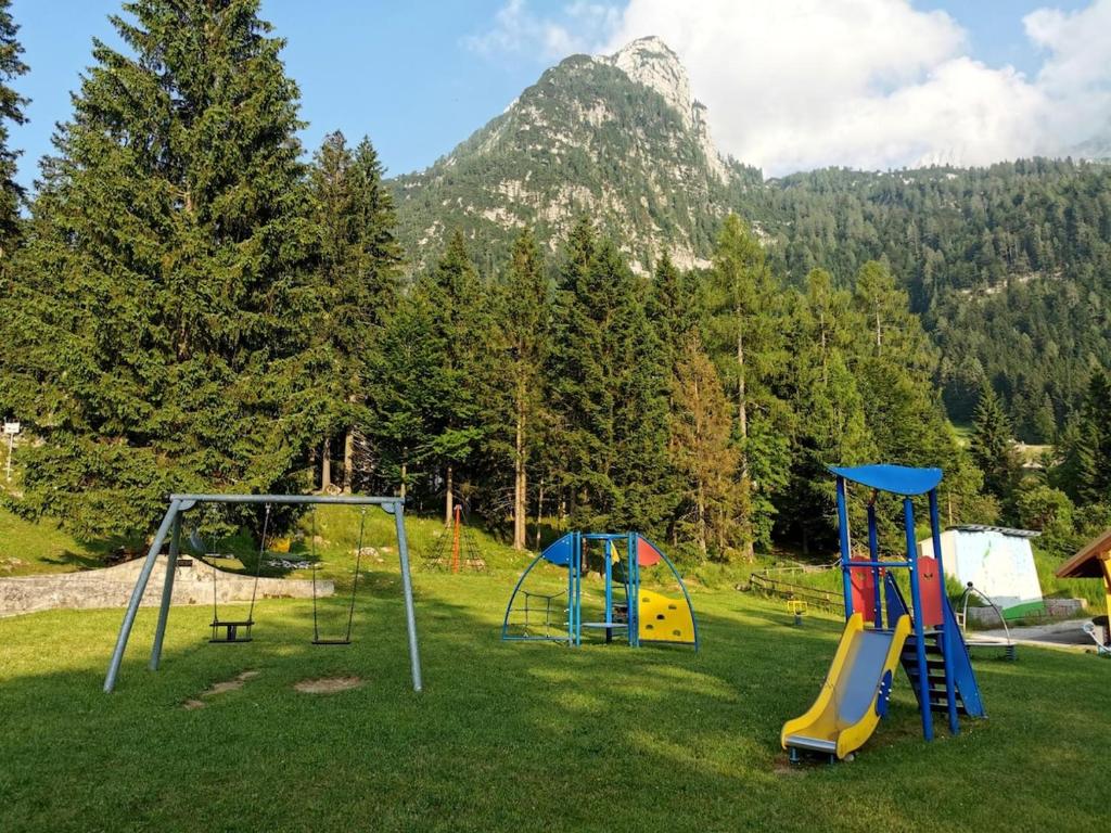 drei Spielgeräte auf einem Feld mit einem Berg in der Unterkunft Alpine Luck Apartment, Sella Nevea in Sella Nevea