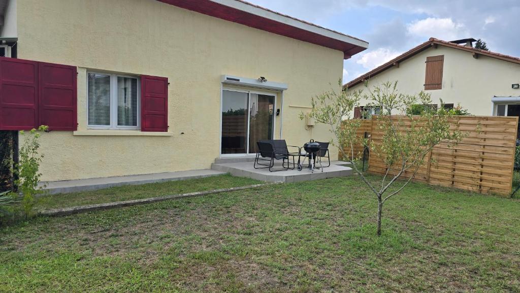 a house with two chairs and a table in the yard at Maison de ville in Pontonx-sur-lʼAdour