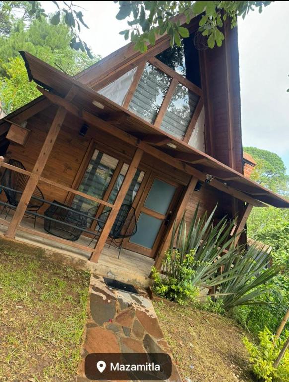 a house with a large window on the side of it at Cabañas el tigre in Mazamitla