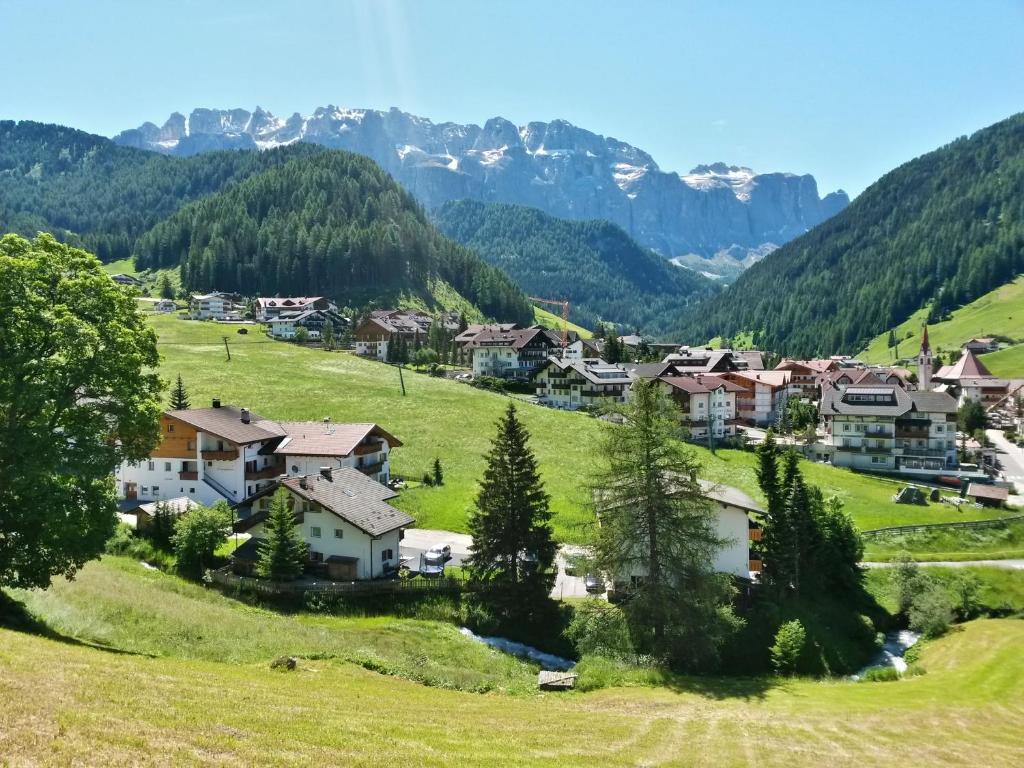 een dorp in een vallei met bergen op de achtergrond bij Garní Nëidia in Selva di Val Gardena