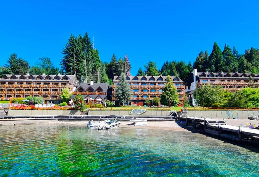 Blick auf ein Resort vom Wasser aus in der Unterkunft Navidad mágica en Manzano Resort Cabaña completa para 8 personas in Villa La Angostura