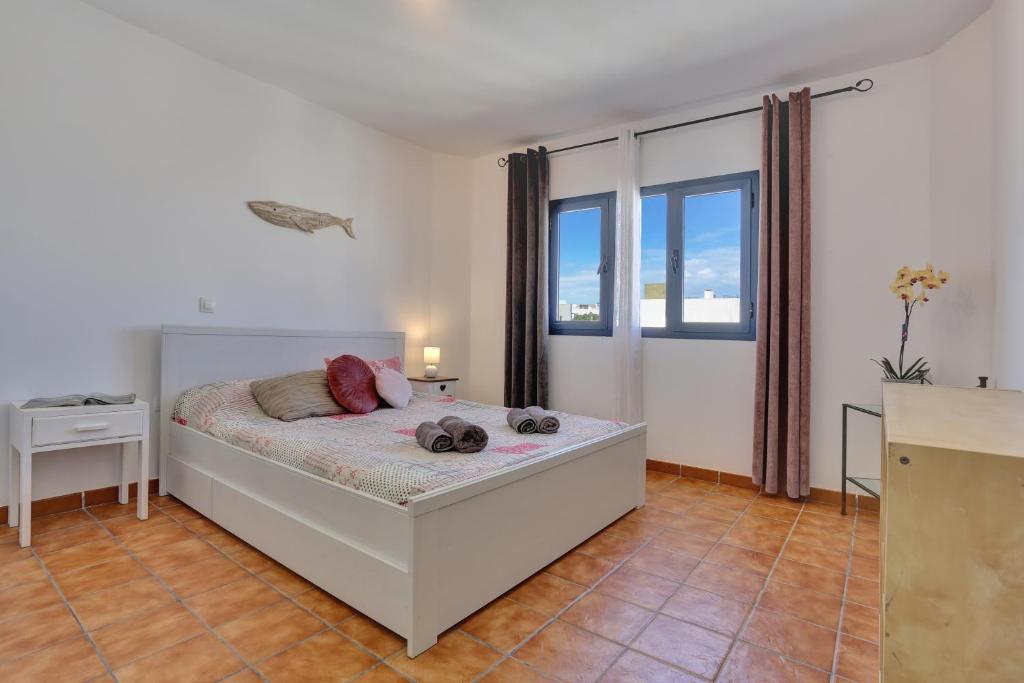 Un dormitorio con una cama y una ventana grande en Casa Marinera El Cotillo duplex for 2-4 persons, en Cotillo