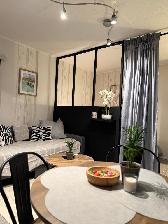 a living room with a table and a couch at Appartement moderne tout équipé in Évreux