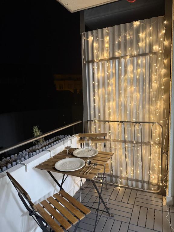 two tables and chairs on a balcony with lights at Modernes Apartment nahe Arena & Mercedes Museum in Stuttgart