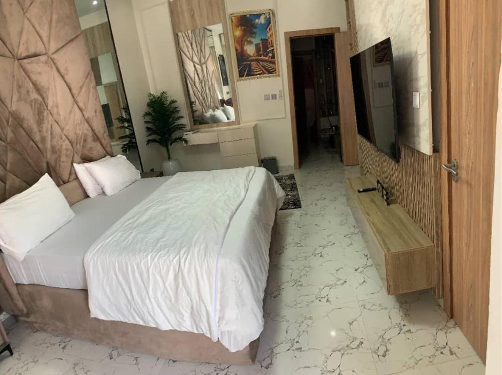 a bedroom with a large bed and a bathroom at Nins Lux suites in Lekki