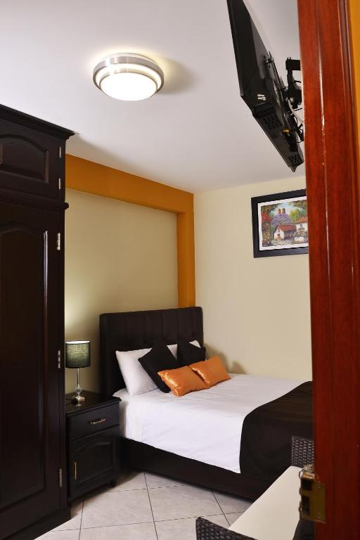 a bedroom with two beds and a flat screen tv at Hostel Esperanza in Lima