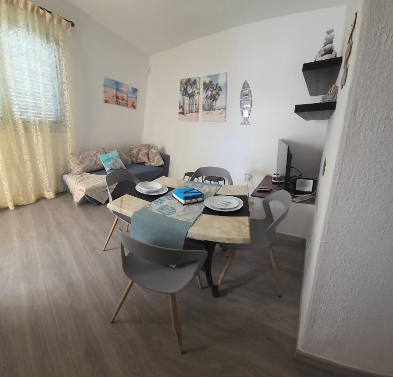 Una sala de estar con una mesa y sillas y un sofá. en Casa Claudia 1 Primero Derecha, en Granadilla de Abona