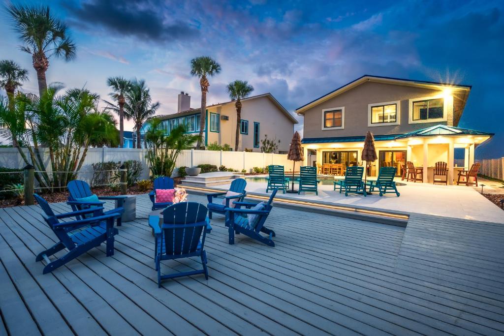 Una terraza con mecedoras azules y una casa. en Luxury Riverfront Oasis Dock Pool & Walk 2 Beach, en Port Orange