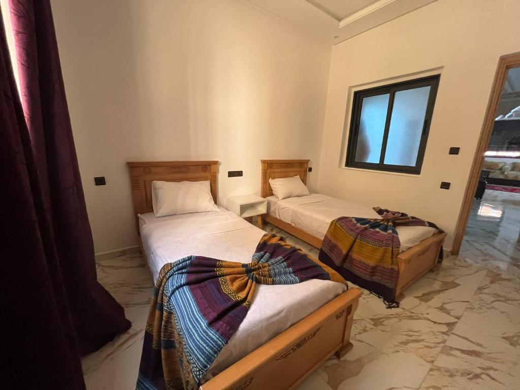 een kamer met twee bedden en een raam bij Mogador Authentique T6 in Essaouira