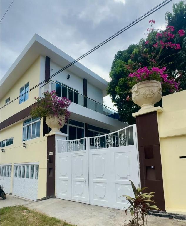 a house with a white gate and flower pots on it at Oasis de Ricaurte in Ricaurte
