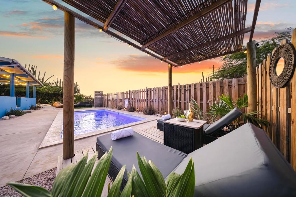 un cortile con piscina e pergolato di New Renovated 3br Escape - 30 Off 4th Night Sept a Oranjestad