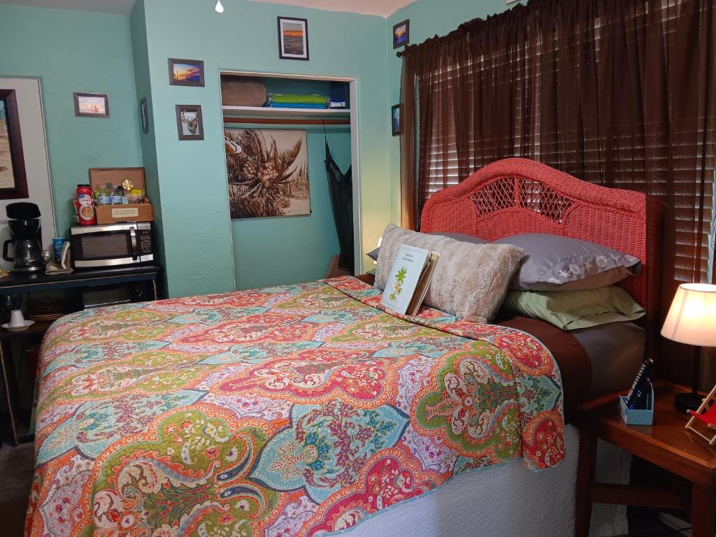 a bedroom with a bed and a table with a lamp at Tropical Hideaway in Daytona Beach