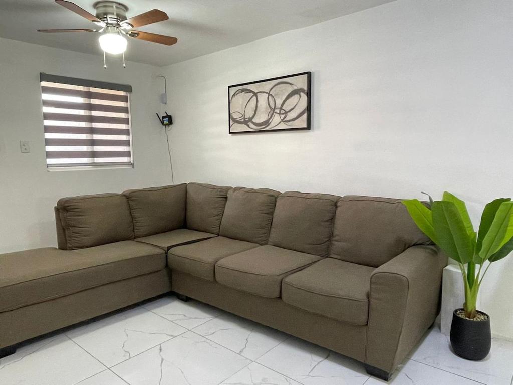 a brown couch in a living room with a ceiling fan at La Alameda you will feel pampered by the comfort in Nuevo Casas Grandes