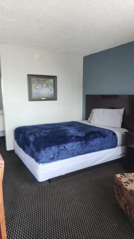 a bedroom with a large bed with a blue blanket at Queen Bed Hotel Room 315 in Amarillo