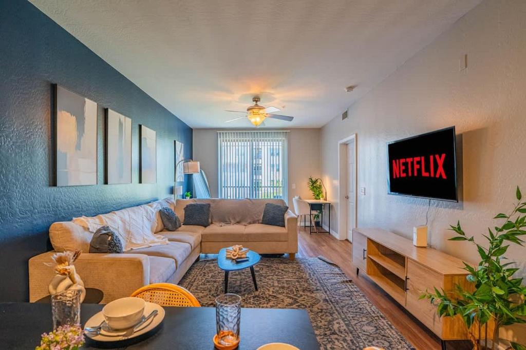 Una sala de estar con un sofá y un televisor. en Spacious Near ASU Sloan Pk Gym Parking Pool WD, en Tempe