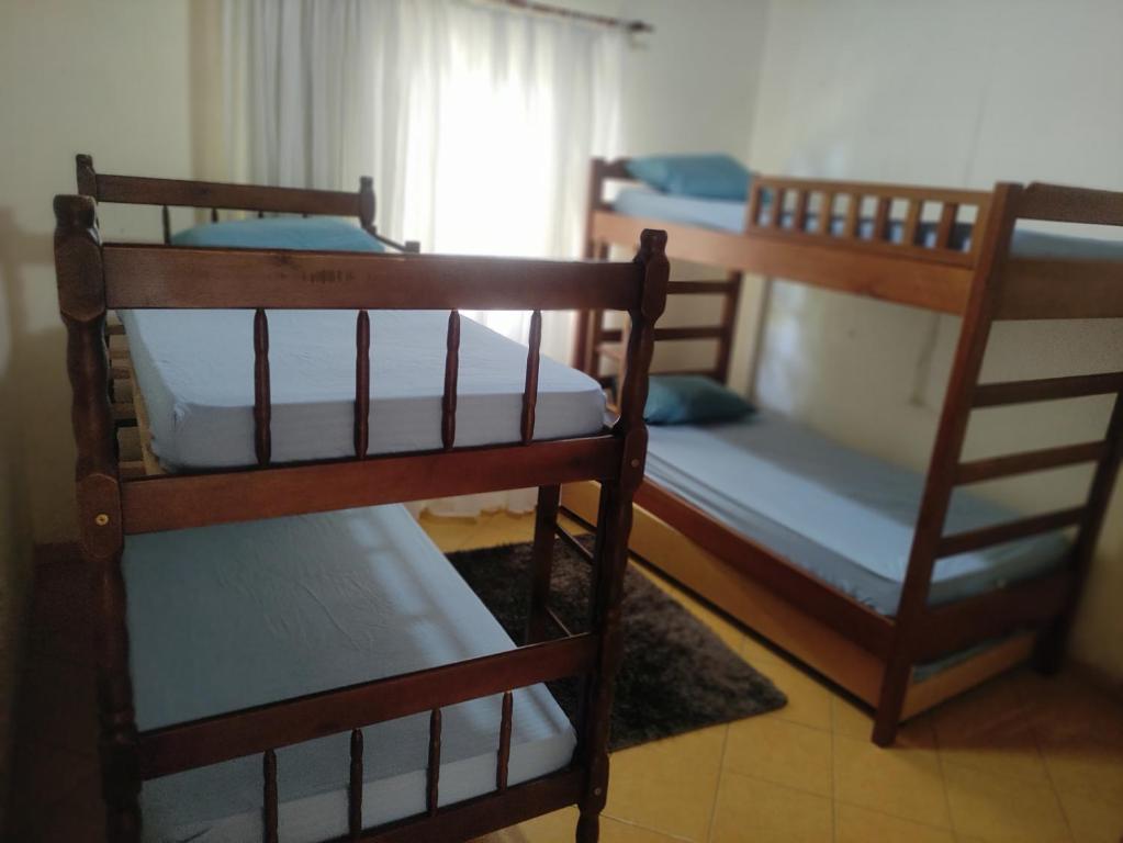three bunk beds in a room with a window at Chácara Recanto in Jarinu