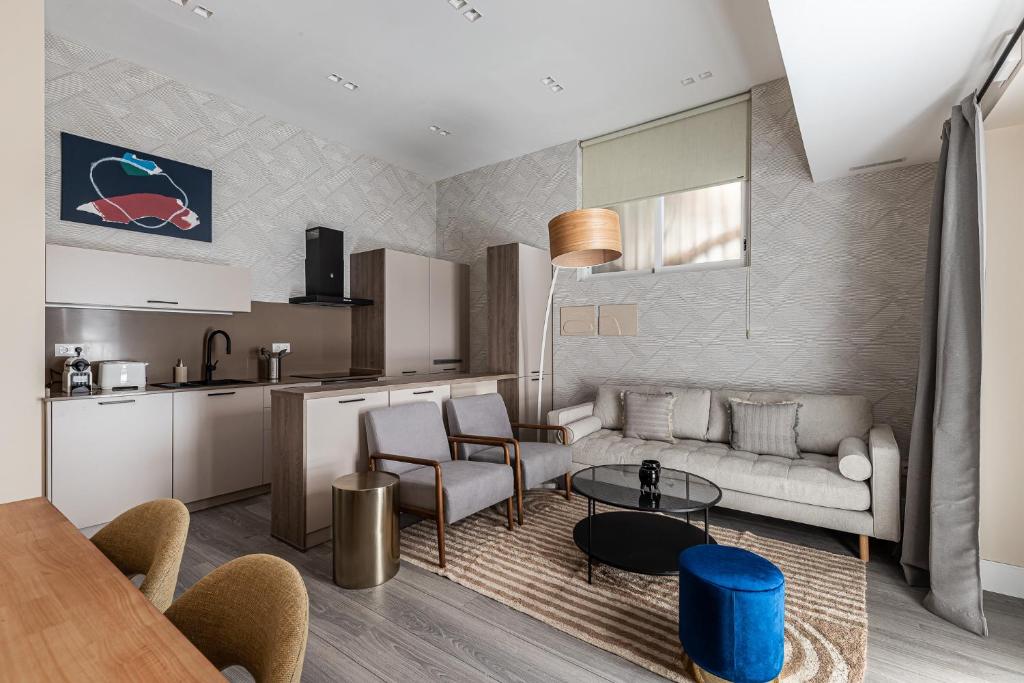 マドリードにあるWaou Glam II Plaza Españaのソファとテーブルのあるリビングルーム