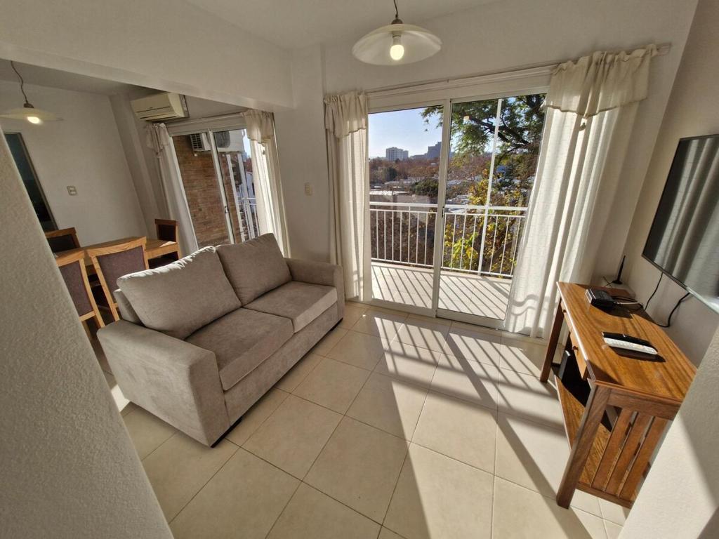 a living room with a couch and a large window at Consorcio 9 de Julio in San Juan