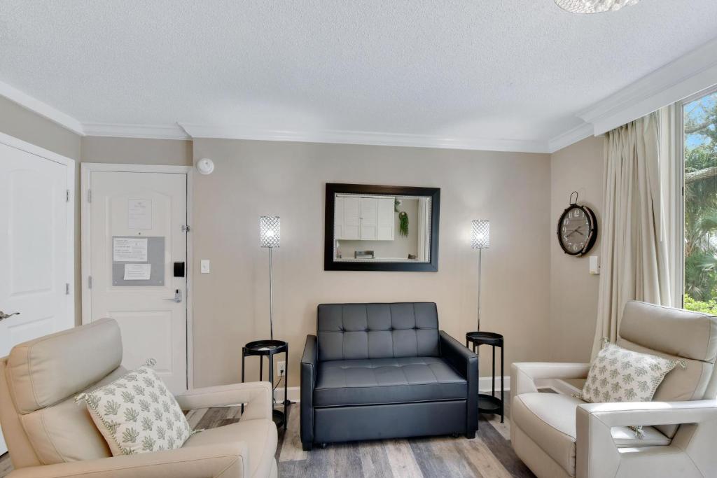 a living room with a couch and two chairs at Villa 401 in Jekyll Island