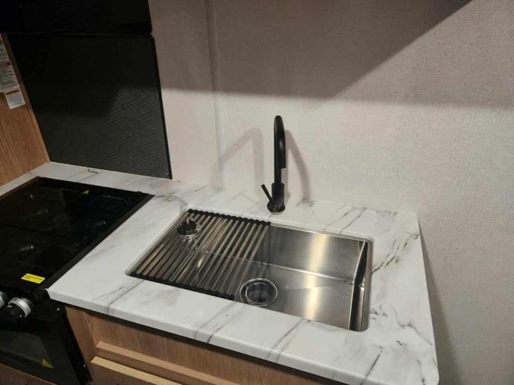 a kitchen counter with a stainless steel sink at Monday creek camper in New Straitsville