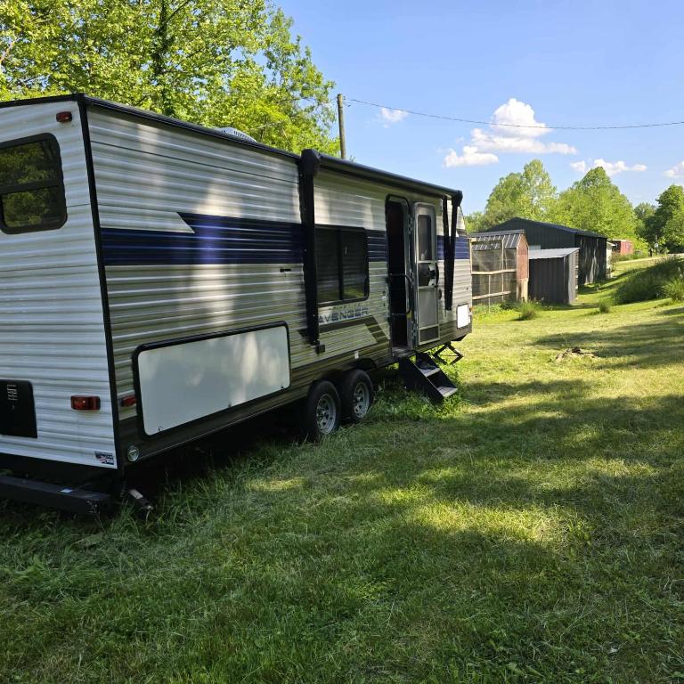a trailer sitting in the grass in a field at Monday creek camper in New Straitsville