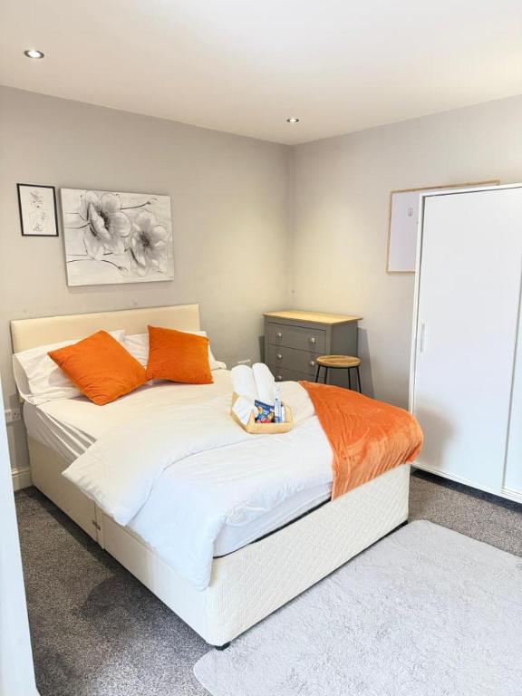 a bedroom with a large white bed with orange pillows at Lovely Double Bedroom in Liverpool