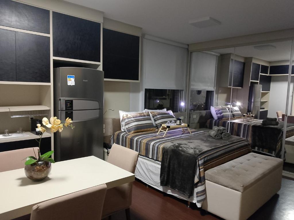 una camera con 2 letti, un frigorifero e un tavolo di Flat Premium Mercure Manaus a Manaus