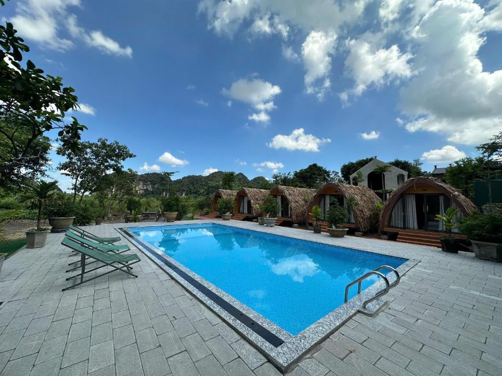 een zwembad met een bank naast een huis bij Bình An Mountain Side Bungalow in Nguyên Ngoại