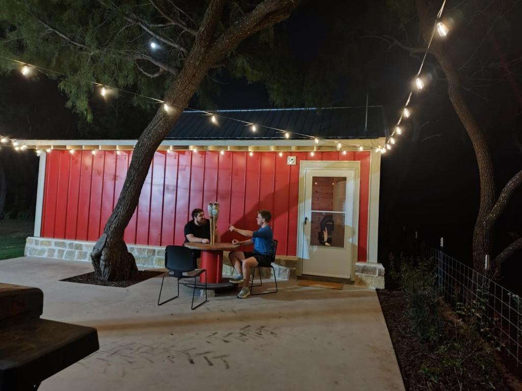 two people sitting at a table in front of a red shed at TheGapCabin in Buffalo Gap