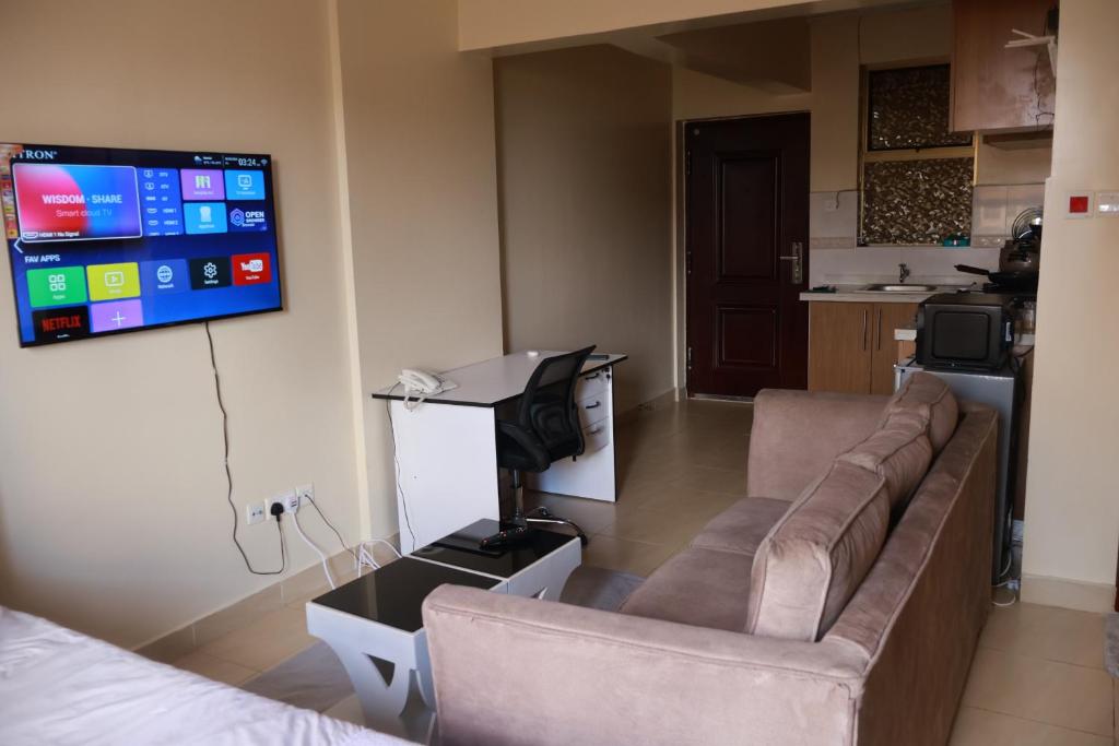 a living room with a couch and a flat screen tv at Maya City View Studios in Nairobi