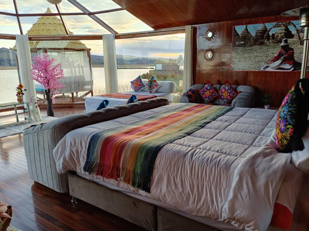 a large bed in a room with a large window at Brisas del Titicaca Perú in Puno