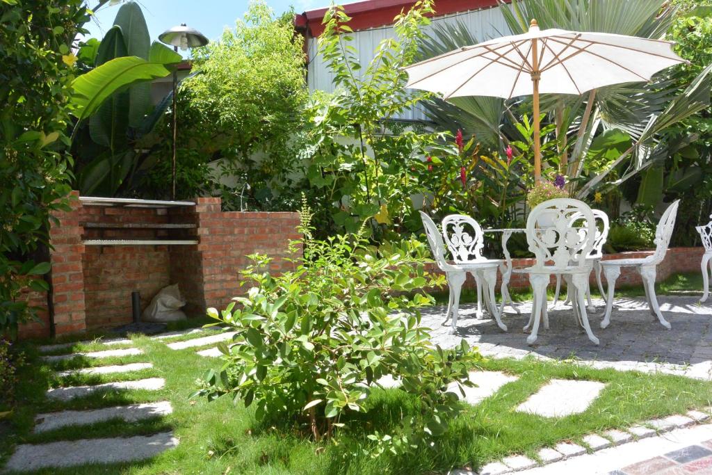 a patio with a table and chairs and an umbrella at Bellalia 貝拉利亞 花蓮民宿 in Hualien City