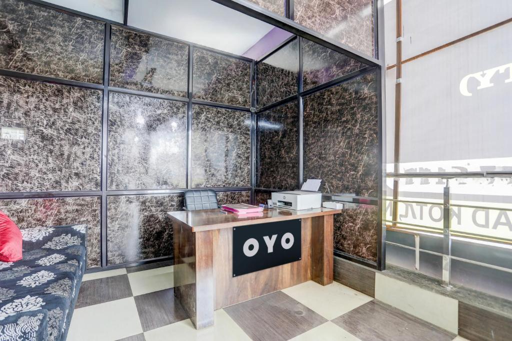 an office with a desk with an ovo sign on the wall at Hotel O Happy Inn in Raipur
